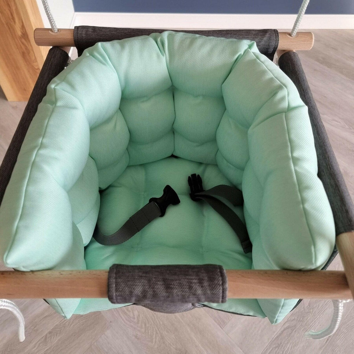Blick von oben in die Schaukel mit mintfarbenen Kissen und Gurt